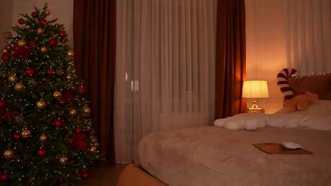 Media: Video of a warmly lit bedroom with a decorated Christmas tree on the left and a bed with a teddy bear and soft lighting on the right.