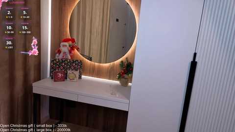 Video of a modern bathroom vanity with a white countertop, circular mirror, and festive decorations including a Santa Claus doll, Christmas cards, and a small tree.