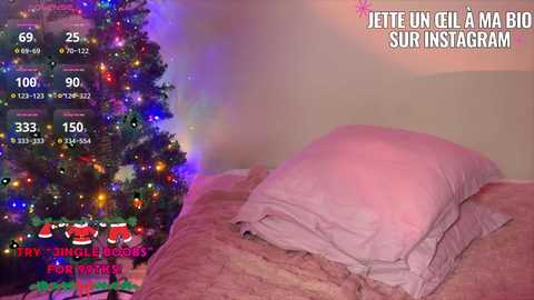 Video of a cozy bedroom with a lit Christmas tree on the left, a pink bedspread, and a pink pillow on the right. Text overlay reads \"Jette un gil a ma big sur instagram.\