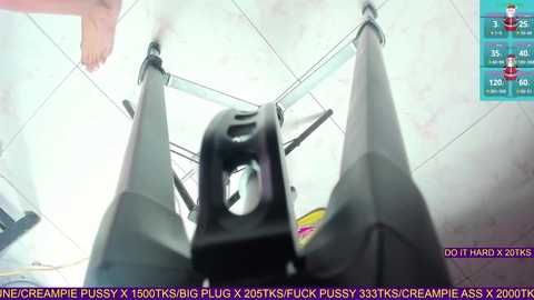 A video of a black, mechanical penis pump, positioned centrally in the frame, surrounded by a tiled ceiling and a hand holding it. Text overlays the image with instructions and a warning.
