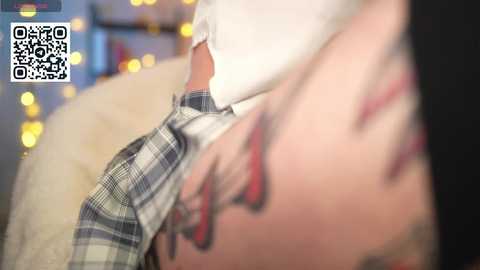 Media: Video of a person in a white shirt, holding up a plaid skirt, with blurred bokeh lights in the background.