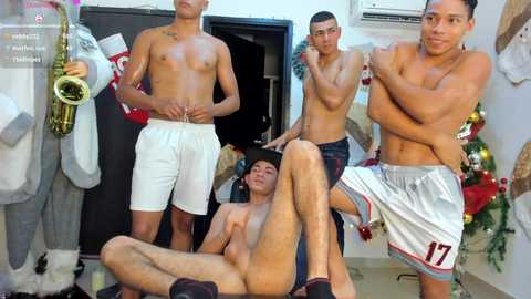 Video of shirtless, muscular men in white shorts, playing instruments, posing in a festive room with Christmas decor.