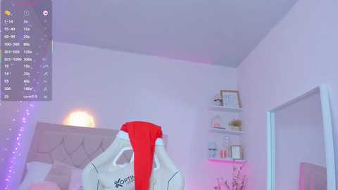 Video of a bedroom with a white bed, a red shirt draped over it, and a soft purple LED strip on the left wall.