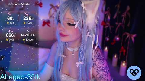 Video of a light-skinned woman with long, pastel blue hair and white bunny ears, dressed in a white lace choker and bra, surrounded by candles, with a virtual avatar overlay.