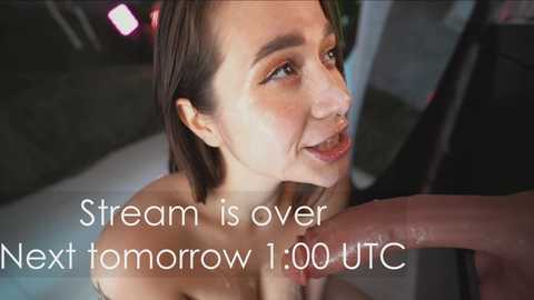 A close-up video of a smiling, topless Asian woman with shoulder-length black hair, being caressed by a hand. Text reads, \"Stream is over. Next tomorrow 1.00 UTC.\