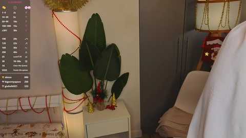 Video of a cozy bedroom with a tall potted plant, a white nightstand, and a plush chair; a digital clock displays the time.