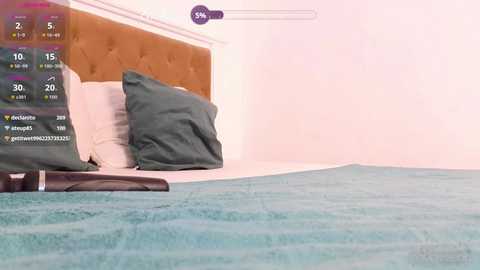 Video of a minimalist bedroom with a tufted headboard, a teal blanket, and dark green pillows on a white bed. A social media notification bar with icons and numbers is overlaid.