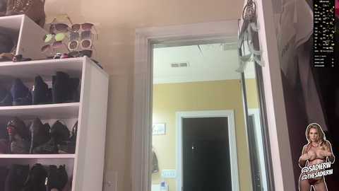 A video of a woman standing in a room with beige walls and a glass door, displaying a small, dark-haired woman in the background.