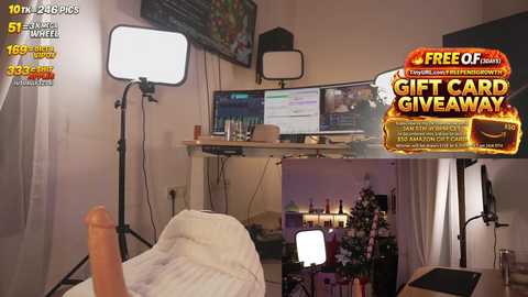 Video of a cozy living room with a bed, desk, computer, and a large, lit-up Christmas tree.