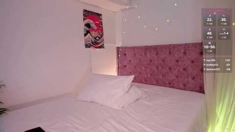 A video of a minimalist bedroom with a white bed, a pink tufted headboard, and a colorful abstract wall painting. The room is softly lit with fairy lights, and a digital clock displays 12:50.