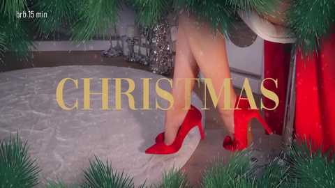 A video of a woman in red high heels and a white dress, stepping out from behind a Christmas tree, with \"CHRISTMAS\" text overlay.