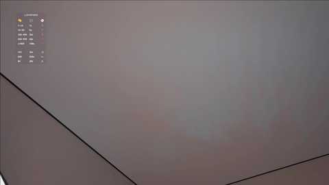 A video of a dimly lit room with a white ceiling, a black cable running diagonally, and a small digital display on the left showing a date, time, and temperature.
