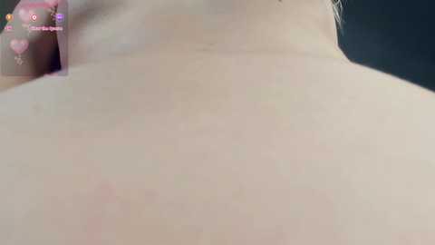 Close-up video of a pale, smooth, female back, with a visible mole, against a dark background. The image is slightly out of focus, with a watermark of \"FEMINIST FEMINISM\" in the top left corner.