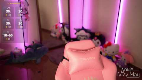 Video of a pink gaming chair in a cluttered, neon-lit room with plush toys, a blue blanket, and a soft toy on the floor.