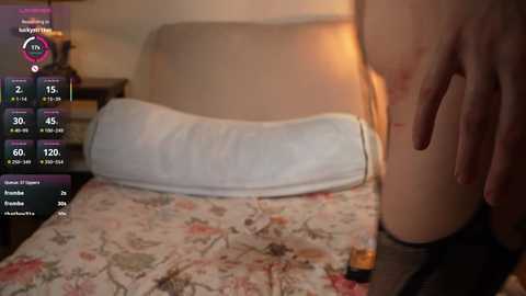 Video of a woman lying on a floral bedspread, with a hand on her thigh, displaying a virtual reality headset.