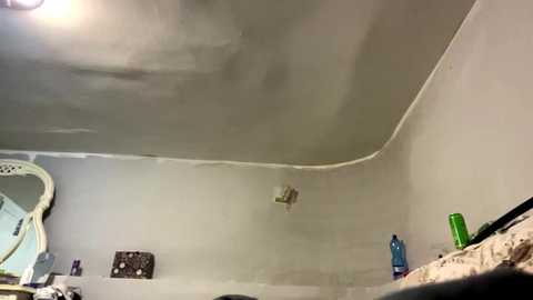 Video of a ceiling with a large water stain, a mirror with a floral frame, and various personal hygiene items on a countertop.