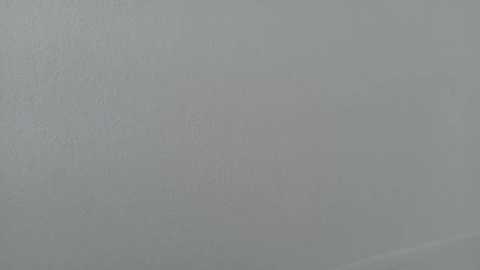 A video of a plain, light gray wall with a subtle, slightly textured surface, featuring no visible objects or decorations, providing a minimalist, neutral backdrop.