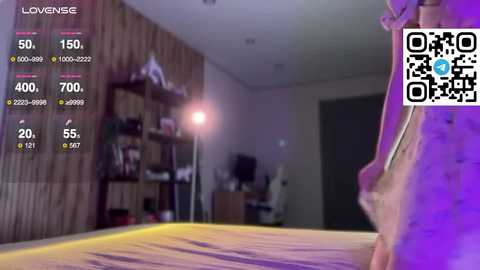 A video shows a blurry bedroom with a person in a white shirt and jeans, a wooden wall, and a QR code on the right.