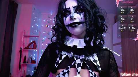 A video of a woman in a gothic, black-and-white checkered costume, with dramatic makeup, in a dimly lit room with a purple and pink light glow.