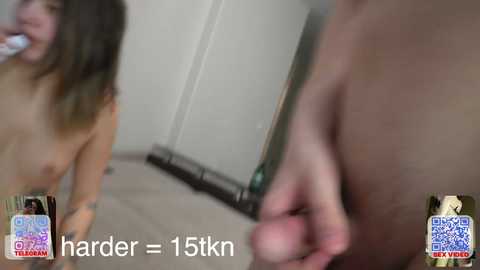 Video of a topless woman with medium breasts and long brown hair, standing in a tiled bathroom, holding a green bottle, with a QR code watermark.