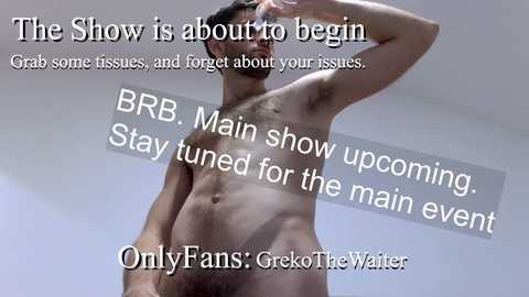 Video of a muscular, nude man with a trimmed beard, holding his hand to his forehead. Text overlays: \"The Show is about to begin\" and \"Stay tuned for the main event.\