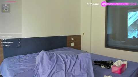 A video of a messy bedroom with a purple bedspread, black and white clothing, a tissue box, and a window with a blue curtain.