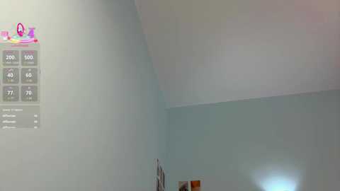 Video of a minimalist, beige-walled room with a large, empty, sloped ceiling. A small, pink, and white \"Smart Home\" logo is visible in the top left corner.