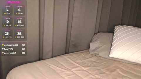 Video of a cozy bedroom corner featuring a neatly made bed with beige sheets and a white pillow. A digital interface on the left displays various temperature settings and icons.