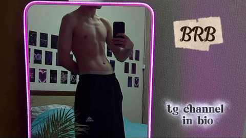 Media: A shirtless, slender, fair-skinned male takes a selfie in a mirror, wearing black sweatpants, in a room with a purple neon light, a bed, and posters on the wall. Text reads, \"to channel in bio.\