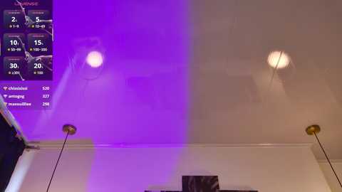 A video of a dimly lit room with purple and white LED lights, showing a digital display with various stats, and two modern gold ceiling lamps.