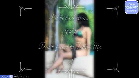 A blurred video of a nude woman with long dark hair, sitting on a white couch, against a lush green background. Text overlays the image with a sad message.