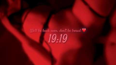 A red-tinted video of a close-up of a woman's bare chest and stomach, with the text \"Will be back soon, don't be bored \u2665 19:10\" superimposed.