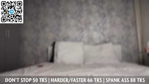 A blurry video of a bed with white pillows and a grey wall in the background. Text at the bottom reads: \"Don't stop 50 TKS / HARDER, FASTER 66 TKS / SPANK ASS 88 TKS.\
