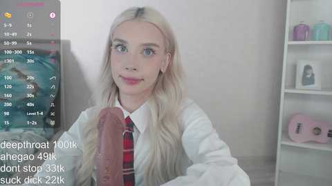 Video of a young, fair-skinned, blonde woman in a white shirt and red tie, with a large, erect penis in her mouth, surrounded by a live-streaming interface with statistics.