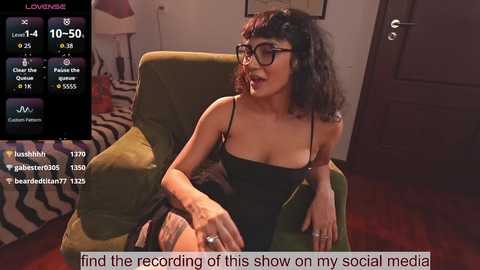 A video captures a woman with curly hair and glasses in a black dress, sitting on a green armchair, with a live stream overlay showing viewers' chat messages.