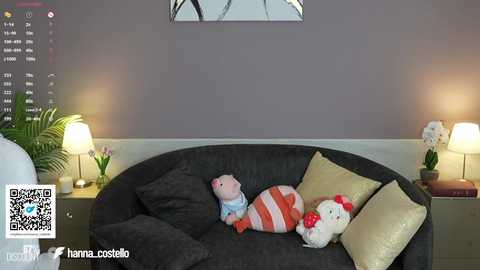 Media: Video of a modern living room with a dark gray sofa adorned with plush toys, including a Hello Kitty pillow and a pink teddy bear. A minimalist wall clock hangs above.