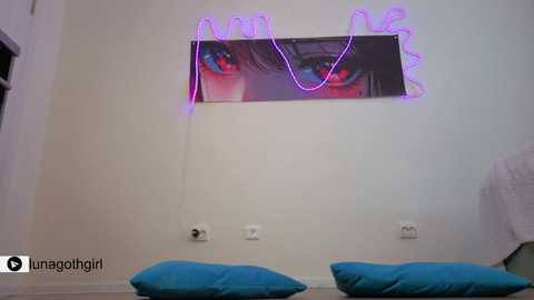 A video of a bedroom wall adorned with a large anime-inspired poster featuring a woman's eye, illuminated by a neon purple light. The room has white walls and two turquoise pillows in the foreground.