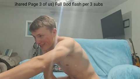 Video of a shirtless, muscular young man with short hair, wearing a blue towel, performing a flash mob dance on a couch in a living room.