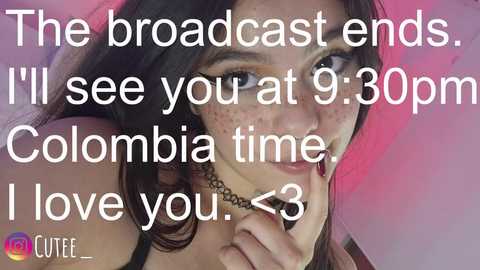 Video of a Colombian woman with dark hair and freckles, wearing a black top, with text overlay reading, \"I'll see you at 9:30pm Colombia time I love you.\