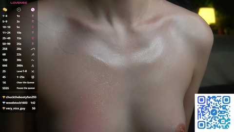 Video of a fair-skinned, topless woman with wet skin, showing a close-up of her chest with small breasts and visible nipples. A QR code is in the bottom right corner.