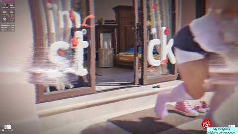 Video of a person running away from a house with a child's face drawn on the door. The person is wearing a white hat and black skirt, and has pink sneakers.