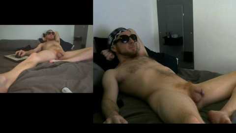 Video of a nude man lying on a bed, wearing sunglasses and a cap, with a woman's hand on his chest.
