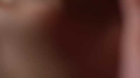 Media: A blurred video featuring indistinct human skin tones in shades of pink, brown, and red, with no discernible features or objects visible.