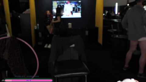 A blurry video of a dimly-lit, modern arcade room with a young woman in a black top playing a video game on a large screen.