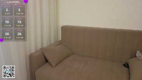 A video shows a beige sofa with a cushion in a dimly lit room. A QR code and a weather app screen with temperature and humidity readings are visible in the top left corner.