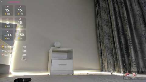 Video of a minimalist, empty room with a white nightstand, gray curtains, and a white floor lamp. A virtual assistant screen with temperature, humidity, and time display is on the left.