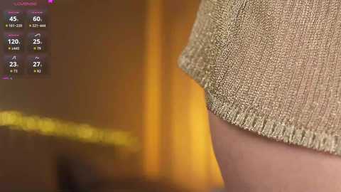 Media: A close-up video of a beige, textured fabric sleeve on a light-skinned arm, with a blurred, warm-toned background. The image includes a digital display showing various temperatures and humidity levels.