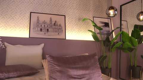Video of a modern bedroom with lavender walls, white pillows, framed black-and-white architectural art, lush green plants, and a round pendant light.