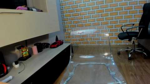 Media: Video of a modern office with a clear plastic mat, brick-patterned wallpaper, black office chair, and black and white cabinets.