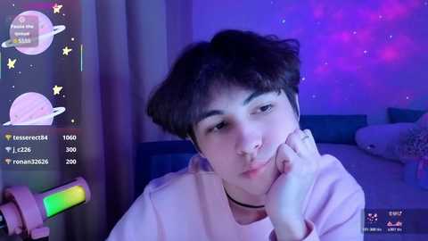 A video of an Asian man with short dark hair, wearing headphones, lying on a bed with a pink blanket, under a purple starry night ceiling.